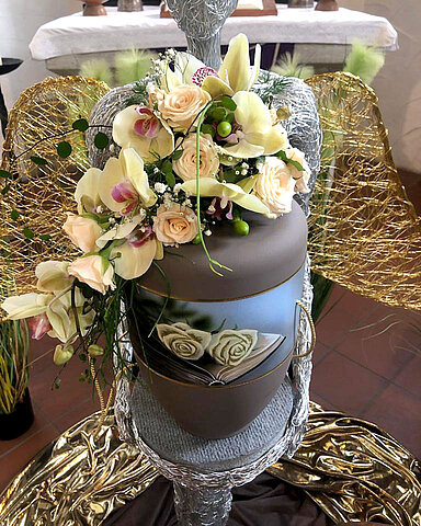 Urne auf Traueralter mit Blumenschmuck