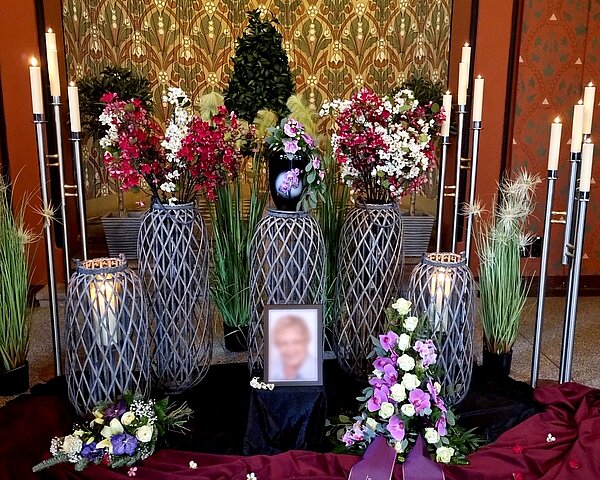 Urne auf Traueralter mit Blumenschmuck